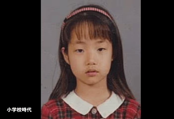 韓国女優パクミニョンの小学校時代の顔画像。
前髪ありのセミロングで、赤と白のギンガムチェックのカチューシャをしている。白襟で赤のチェックのシャツを着用。
